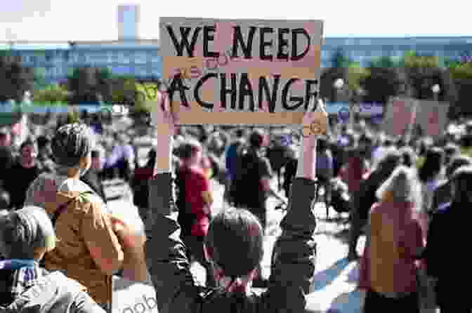 A Group Of People Standing Together, Holding Signs And Protesting. The Anti Inauguration: Building Resistance In The Trump Era